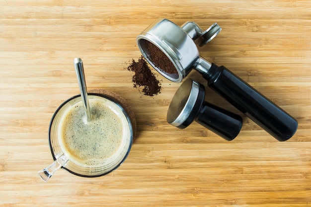 Tasse d&#39;espresso sur planche de bois avec du café moulu