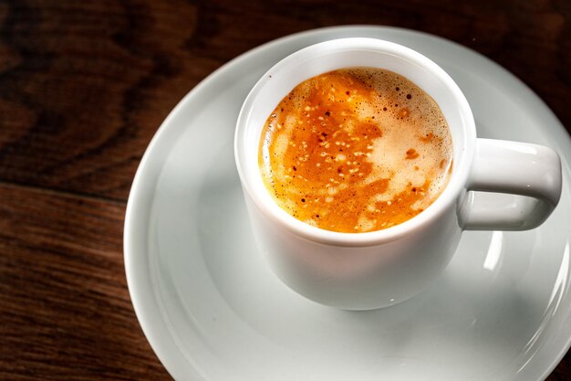 Tasse d'espresso sur une soucoupe blanche gros plan et vue de dessus