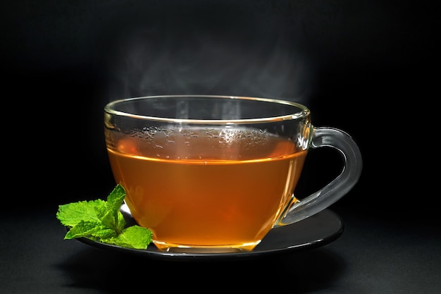 Tasse avec des feuilles de menthe sur fond noir libre