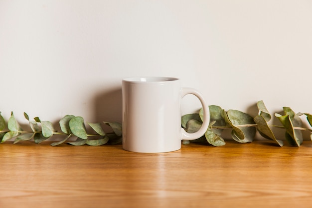 Photo tasse et feuilles sur la surface en bois