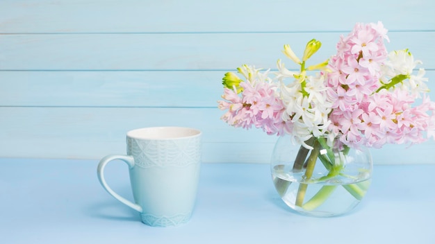 Photo une tasse de fleurs à côté d'une tasse bleue