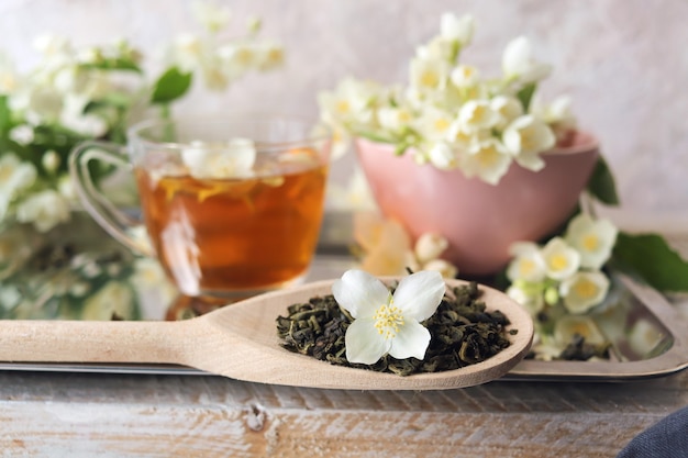 Tasse de fleurs de jasmin de thé vert sur les ingrédients de table d'une boisson saine