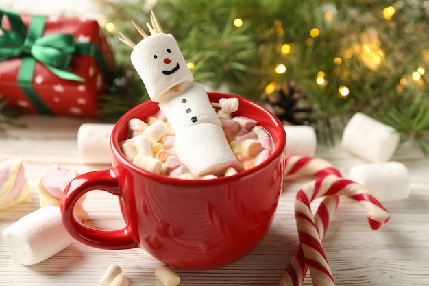 Tasse avec guimauve bonhomme de neige sur fond de bois de Noël