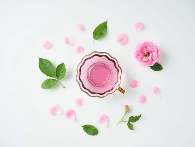 tasse avec de l'huile extraite de roses