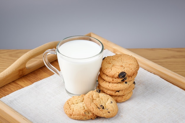 Tasse De Lait Et Biscuits Aux Raisins Secs Sur Un Plateau En Bois