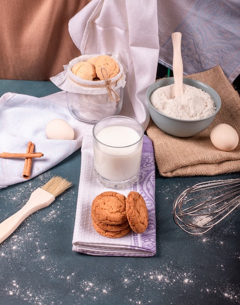 Tasse de lait avec des biscuits à la cannelle et de la farine