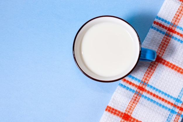 Tasse de lait bleu sur fond bleu clair. Vue d'en-haut.