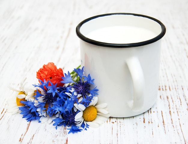 Tasse de lait et fleurs sauvages