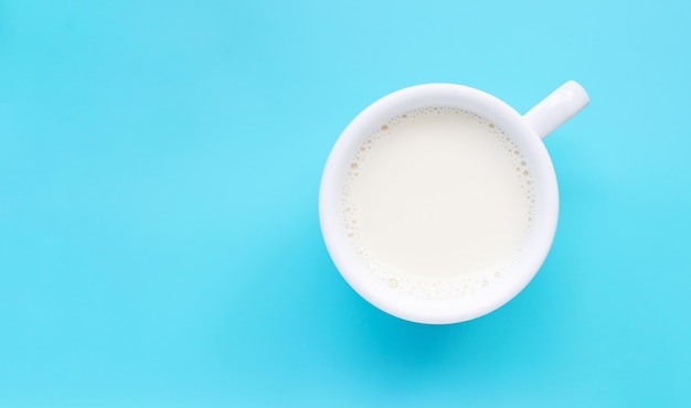 Tasse de lait sur fond bleu.