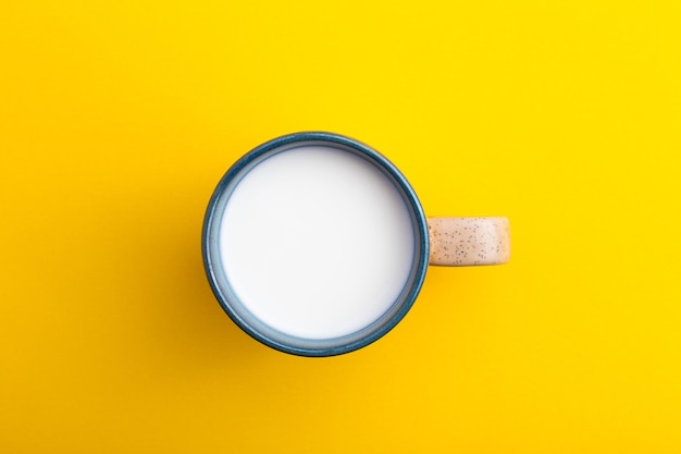 Une tasse de lait vue de dessus sur fond jaune