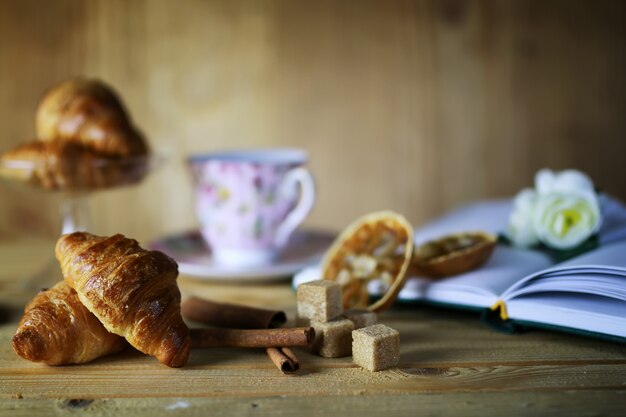 Tasse avec livre de croissants au thé