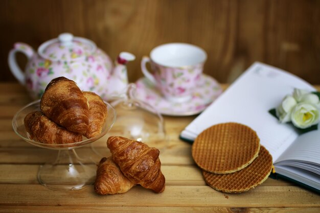 Tasse avec livre de croissants au thé