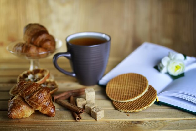 Tasse avec livre de croissants de thé