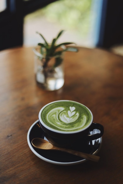 Une tasse de matcha latte sur une table en bois