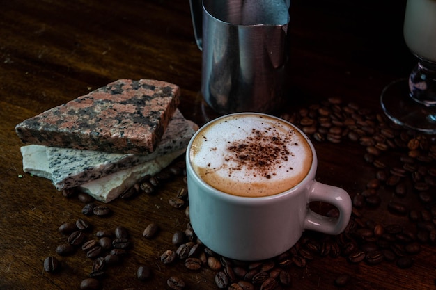 Photo tasse avec mousses de cacao et étincelles et grains de café et pichet