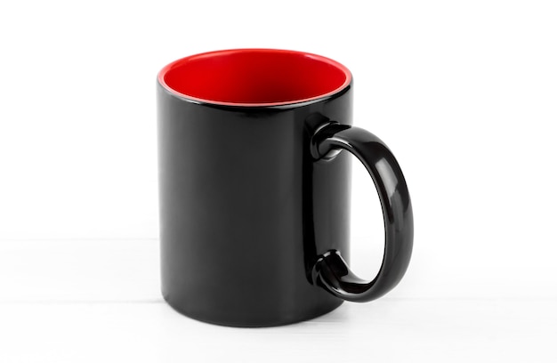 Tasse noire vide avec du rouge isolé sur fond blanc