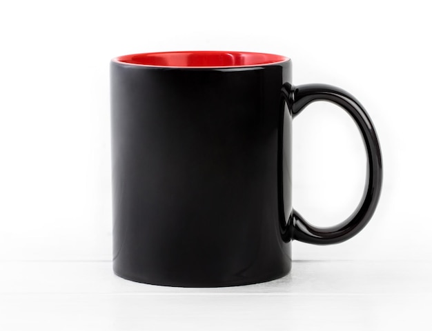 Tasse noire vide avec du rouge isolé sur fond blanc