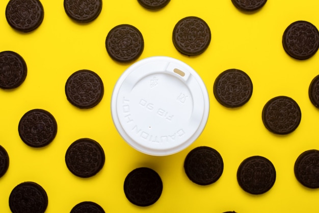 Tasse en papier et biscuits aux pépites de chocolat sur un jaune