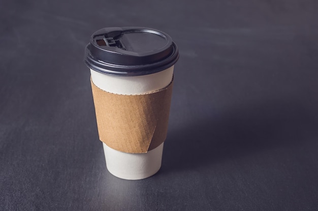 Tasse en papier blanc pour le café sur fond noir