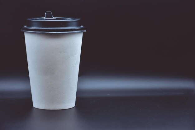 Tasse en papier blanc pour le café sur fond noir