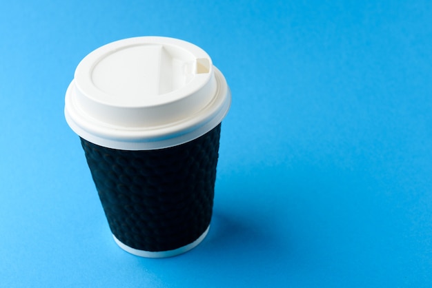 Tasse de papier de café sur fond bleu.