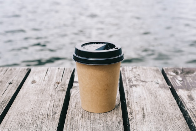 tasse de papier à café sur fond en bois et mer marron. fond