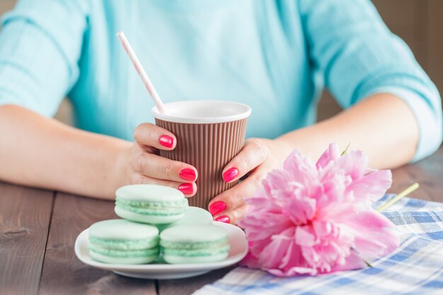 Tasse de papier de café et macarons sur table