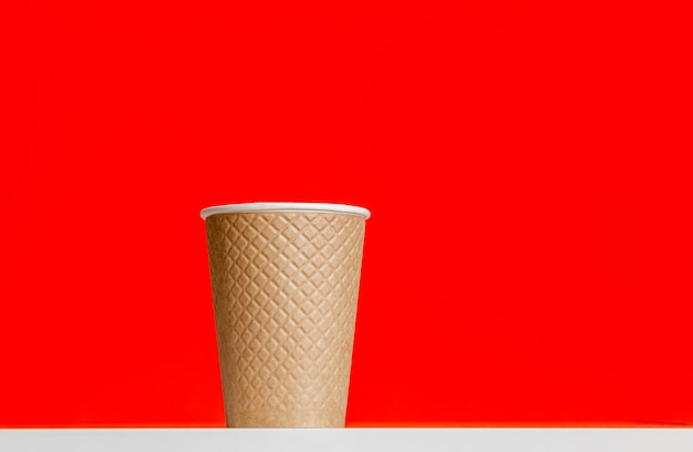 tasse en papier texturé sur fond rouge