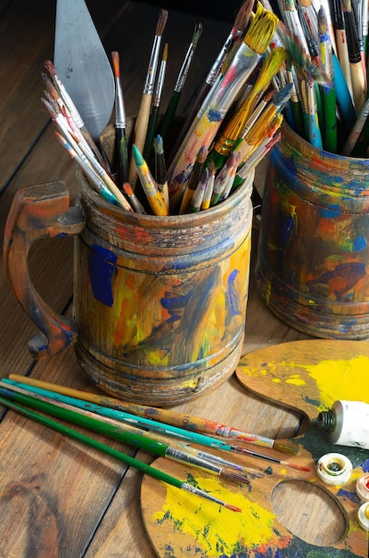 Une tasse de peinture est remplie de peinture et d'un pinceau.