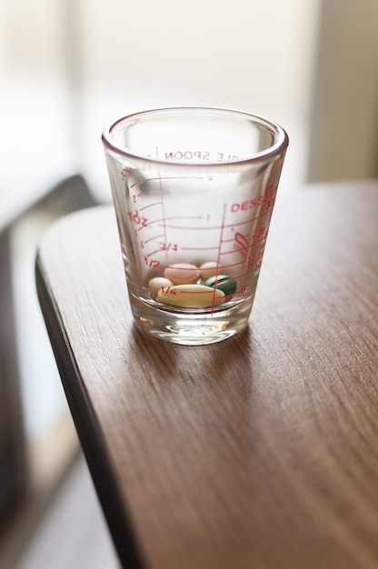 Tasse de pilules sur la table en bois