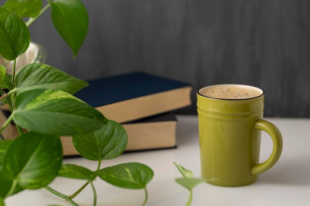 Tasse de plants de café et de livres sur un bureau