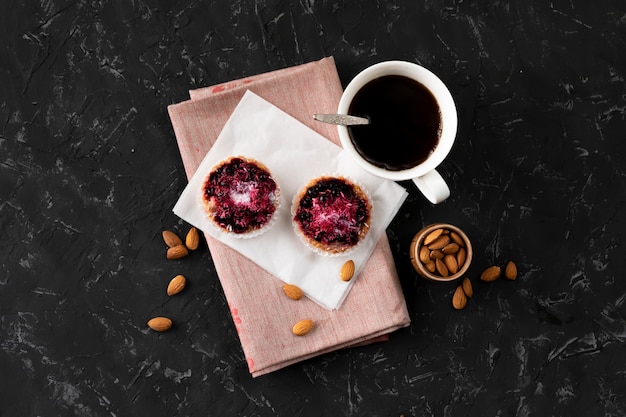 Tasse plate avec café chaud, gâteau sucré sur une table noire, petits déjeuners cuisinés à la maison