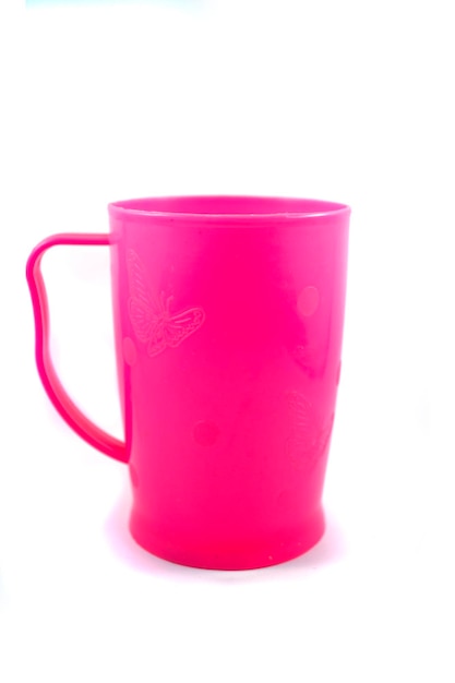 Tasse à poignée en plastique rose isolé sur fond blanc