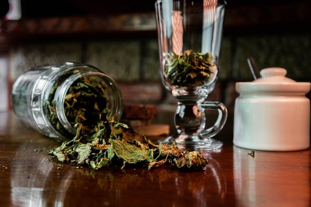 Photo tasse et pot en verre avec des feuilles séchées pour infusion