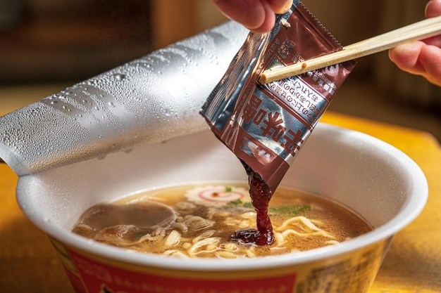 Une tasse de ramen avec une étiquette qui dit "le ramen" dessus