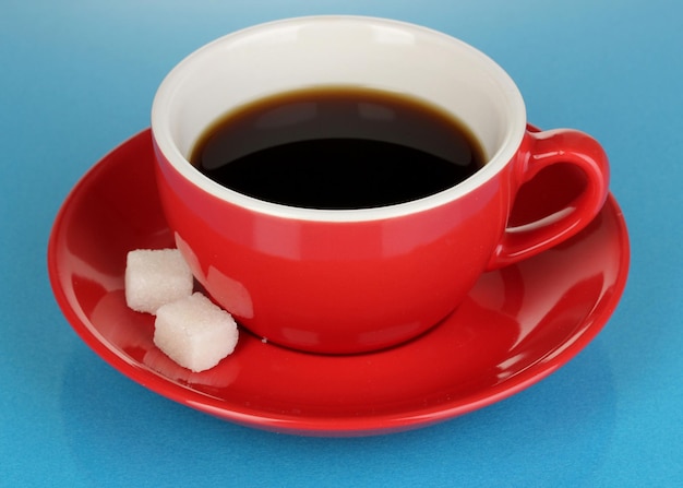 Une tasse rouge de café fort sur fond bleu