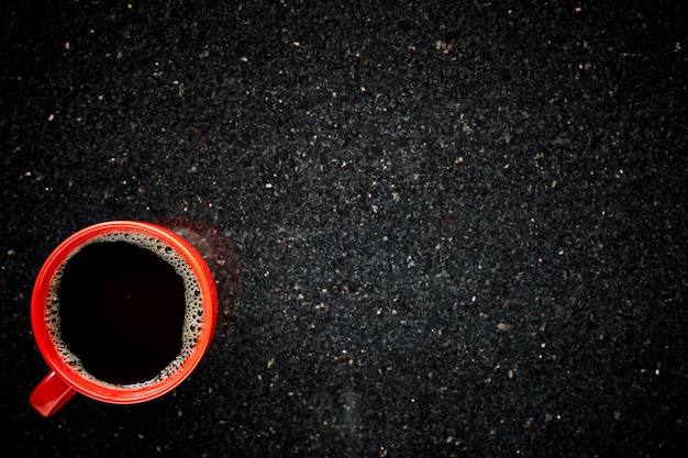 Tasse rouge de café noir le matin