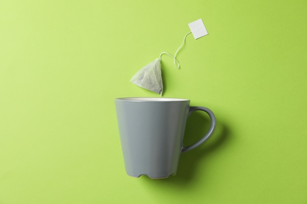 Tasse et sachet de thé sur vert, espace copie