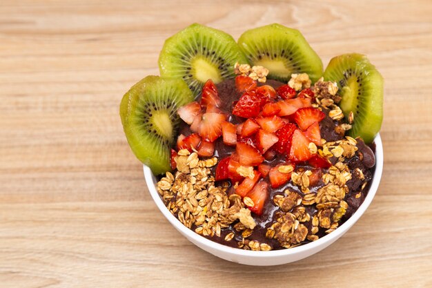 Tasse de soverte avec kiwi, fraise et granola.