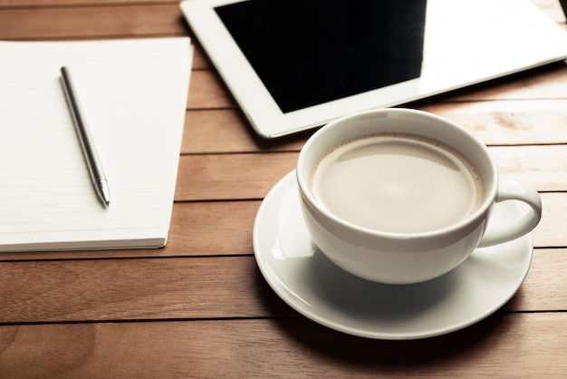 Tasse de tasse de café sur le bureau avec le stylo de carnet