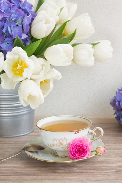 Tasse de thé antique avec des tulipes blanches