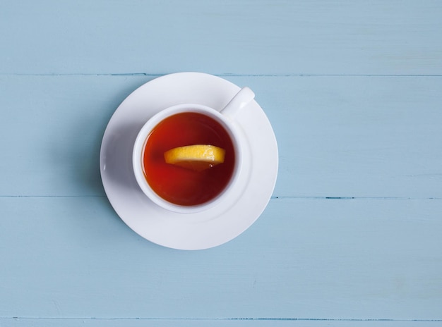 Une tasse de thé au citron sur des planches bleues Vue d'en haut