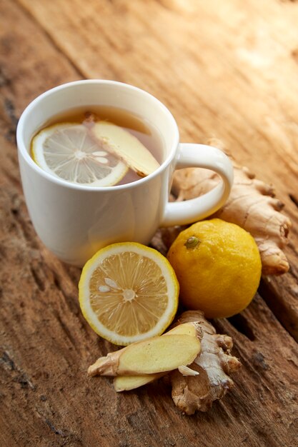 Photo tasse de thé au gingembre au citron sur bois