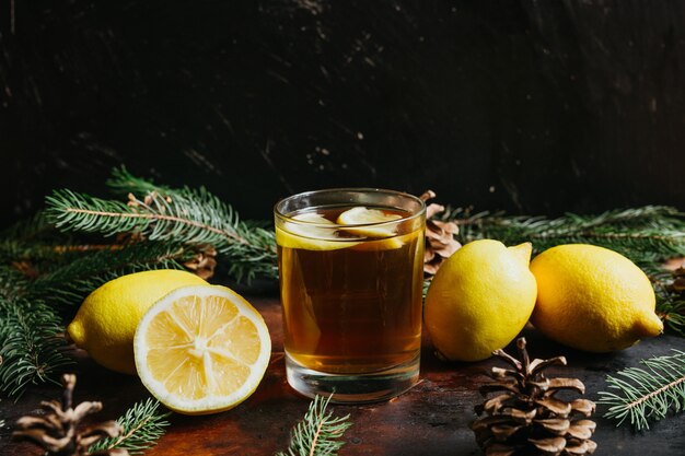 Tasse de thé aux citrons de citron avec des branches de sapin pour un fond rustique. Boisson naturelle.