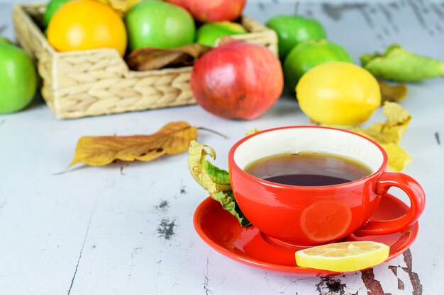 Tasse de thé aux fruits au citron. Agrumes tropicaux sur la table rustique blanche.