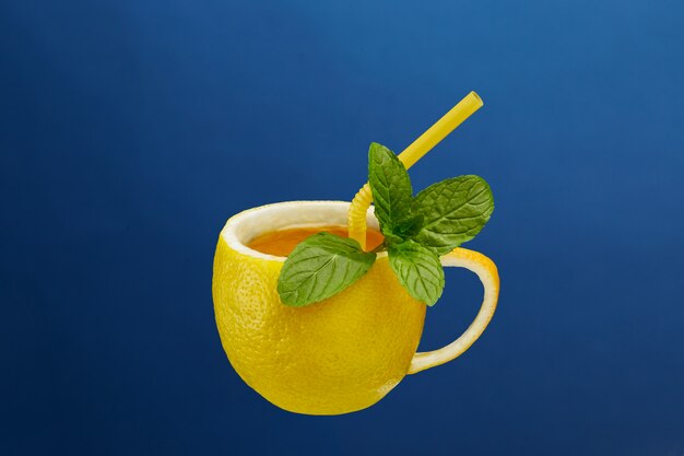 Une tasse de thé à base de citron naturel avec des feuilles de menthe. Composition créative sur le thème du thé naturel