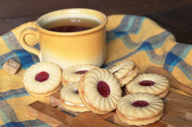 Tasse de thé et biscuits avec de la confiture pour le petit déjeuner sur la table