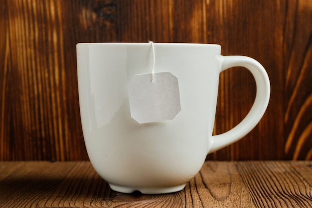 Une tasse de thé blanc avec une étiquette d'un sachet de thé