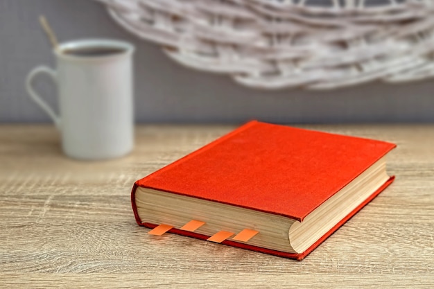 Photo tasse de thé blanc et un livre sur une table en bois