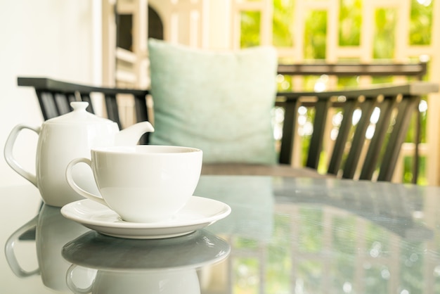 tasse de thé blanc avec théière sur table